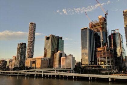 Brisbane city skyline at golden hour; illustrative photograph, not a specific community housing project.