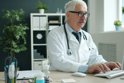 Clinician working at a computer; stock illustration of digital clinical documentation, not a Heidi customer or team member.