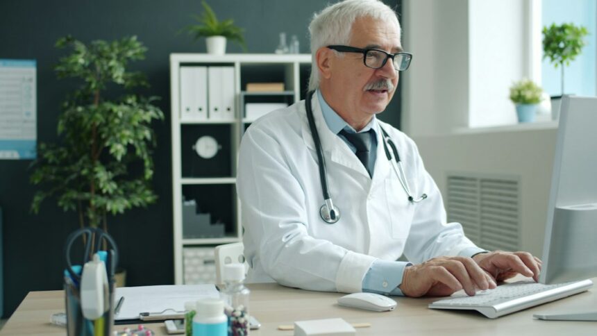 Clinician working at a computer; stock illustration of digital clinical documentation, not a Heidi customer or team member.